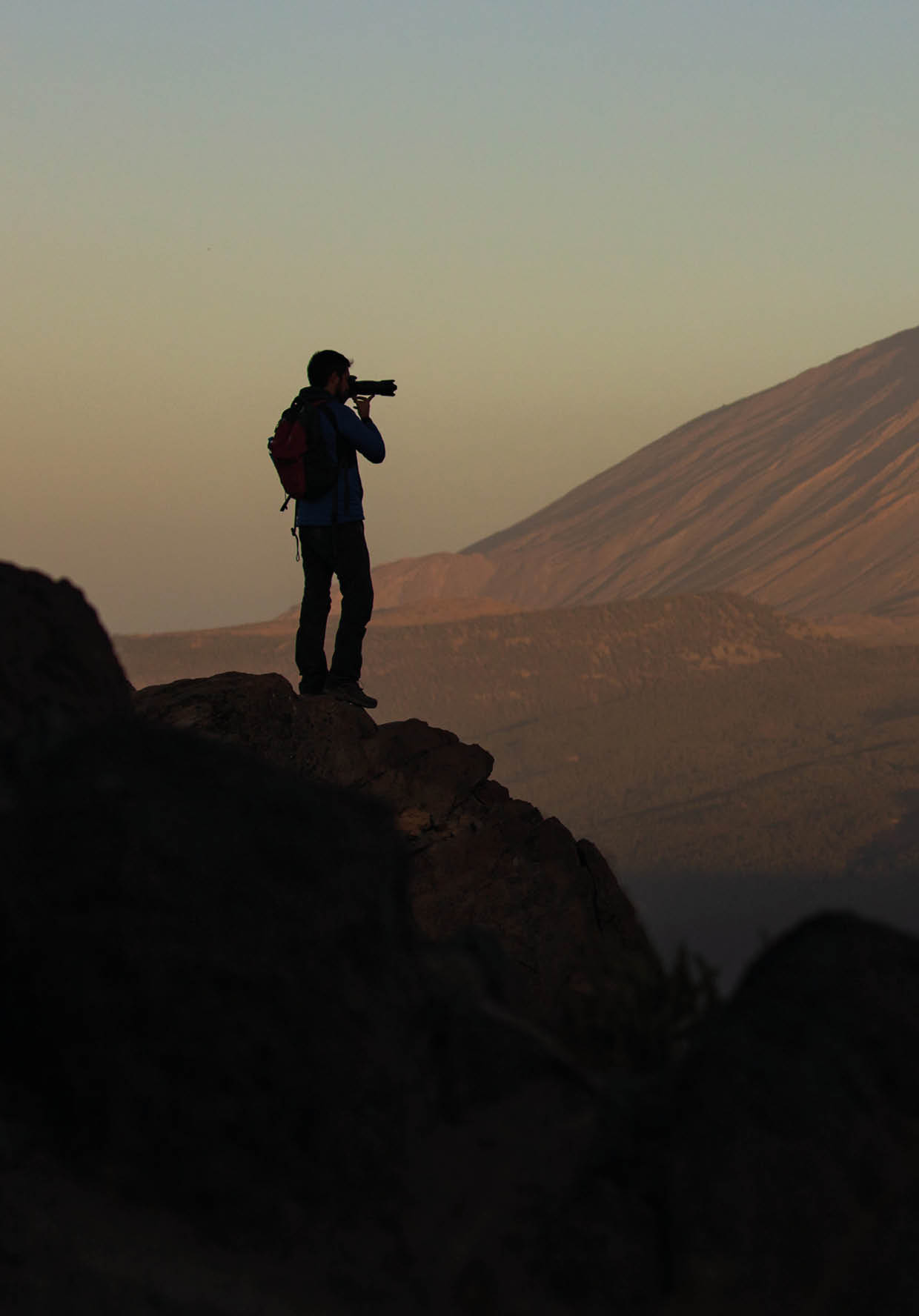 A photographer and the first lights of the day on Teide volcano   Location: Teide National Park, Tenerife, Canary Islands, Spain  Photographer: Edson Vandeira