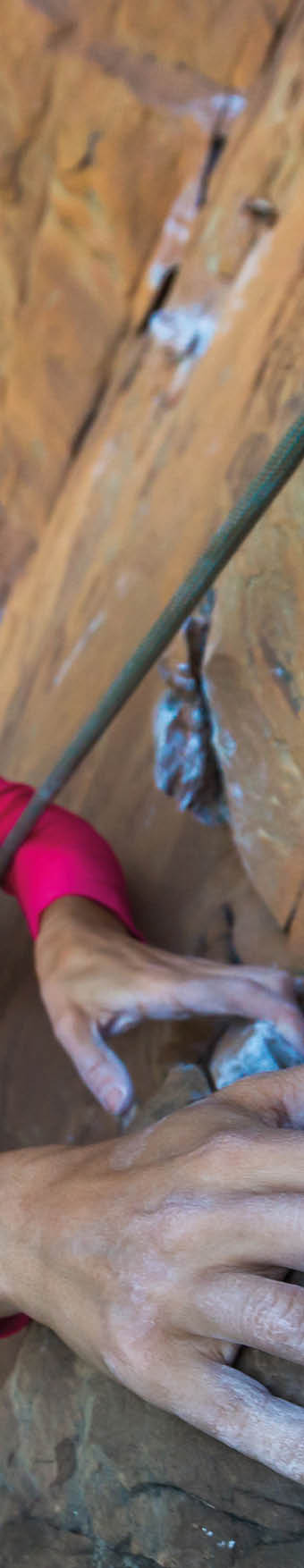 Woman climbing on rock. Location: Conceicao do Mato Dentro, Tabuleiro Falls, Minas Gerais, Brazil  Photographer: Edson Vandeira