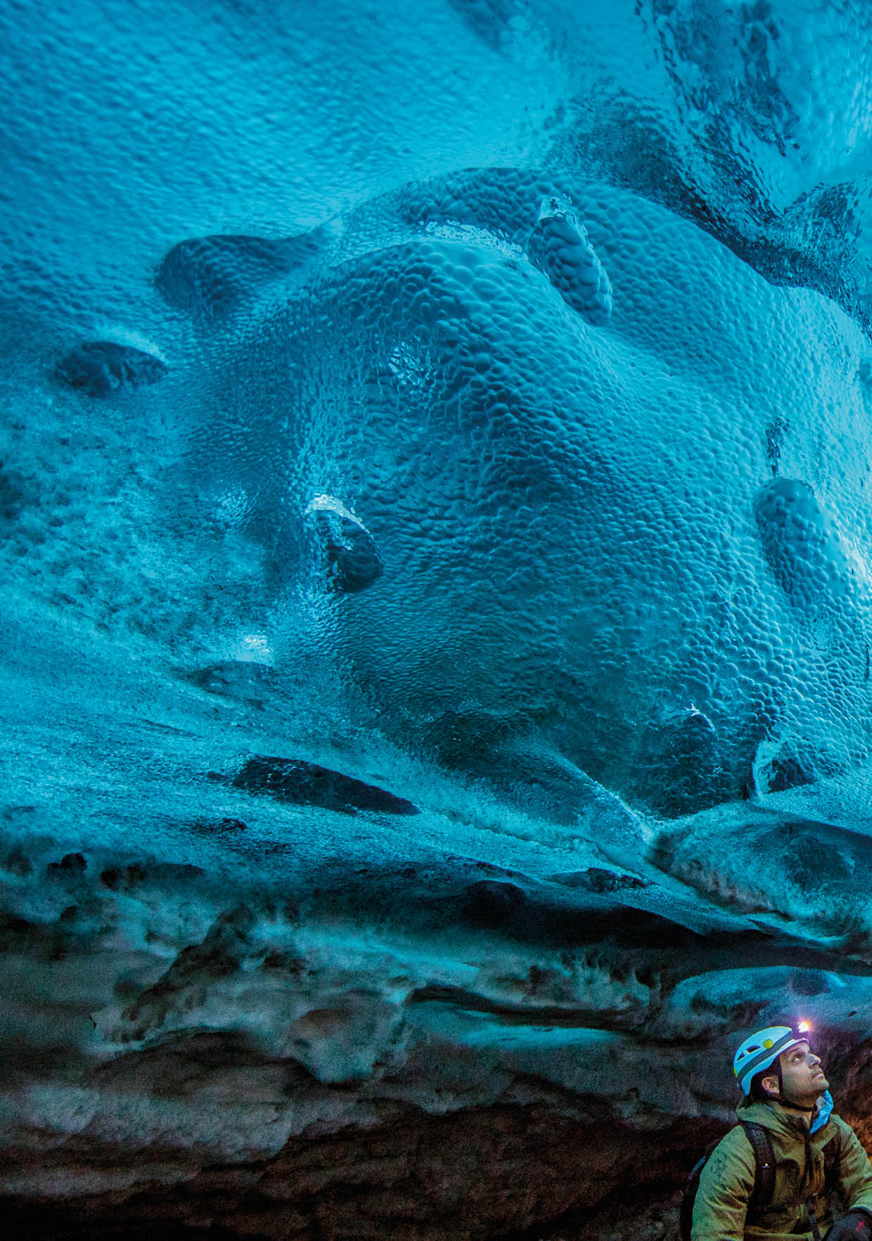 A man looking up at the ice in a glacier cave. Location: Eastern Region, Iceland Photographer: Ben Horton