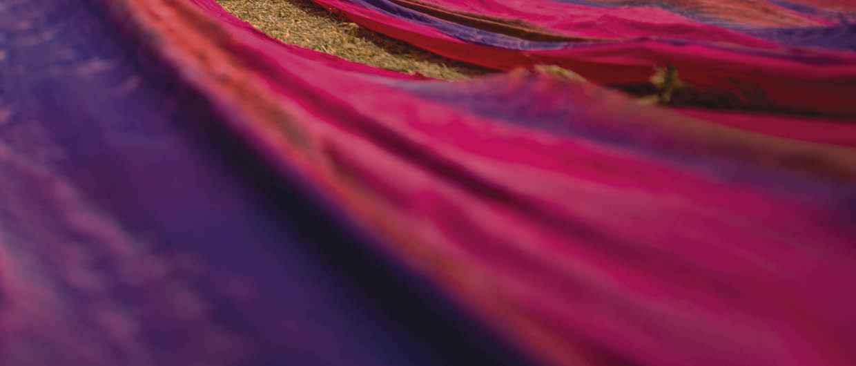 Long rolls of traditional fabric rolled down a hill to dry in the sun, creating a sea of color, Indonesia. ©Chue Ardi RH 1A and 1B cover image