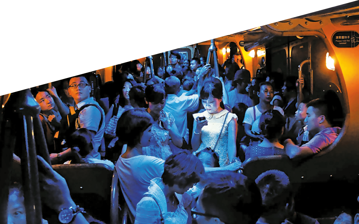 On a hot day in Hong Kong, people crowded into an air-conditioned train. When the lights dimmed, one young woman stood out, lost in the glow of her own digital world.