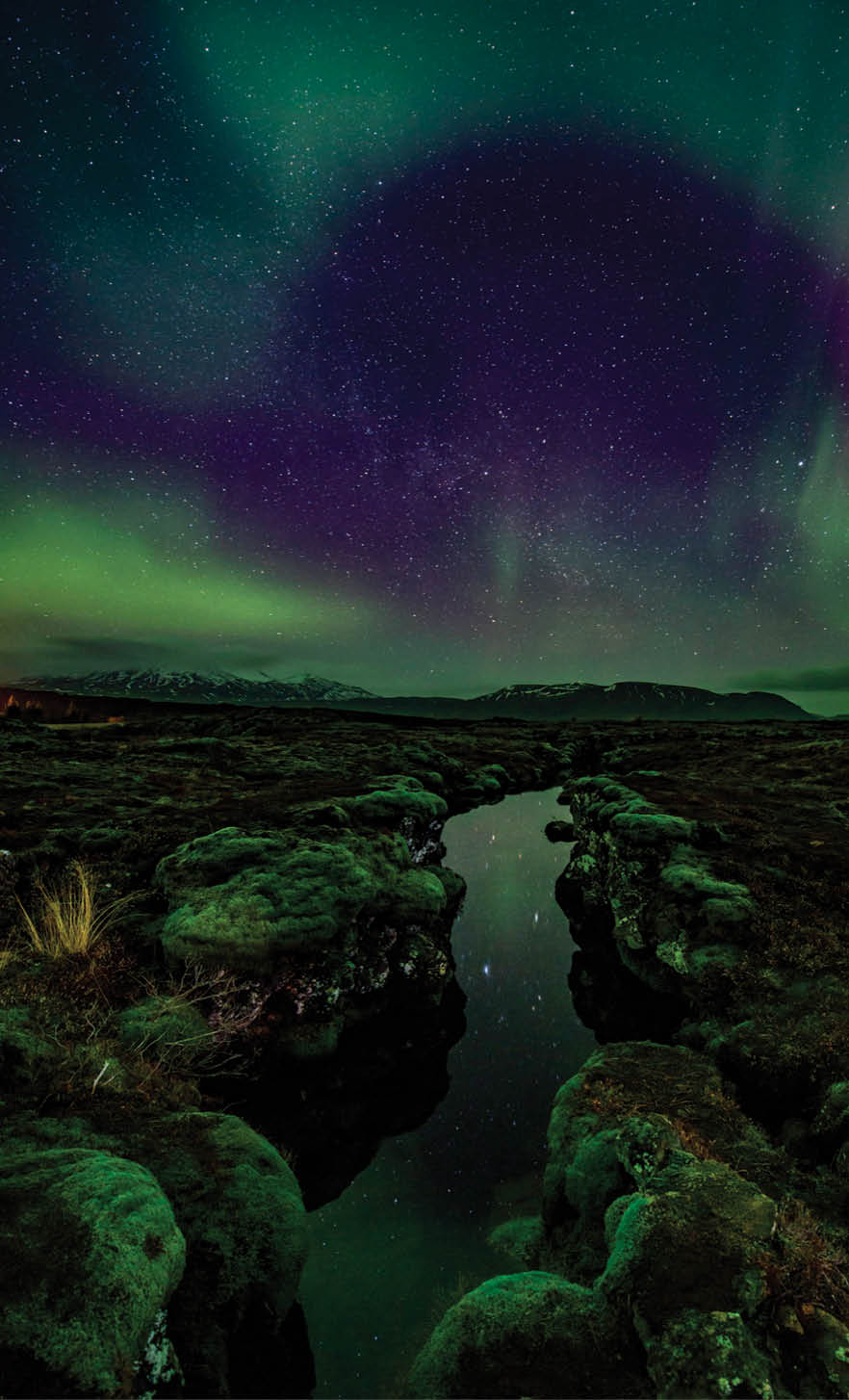 Aurora over the Silfra rift on the tectonic plates which straddle Iceland. The rift is full of gin clear water which is reflecting the aurora.