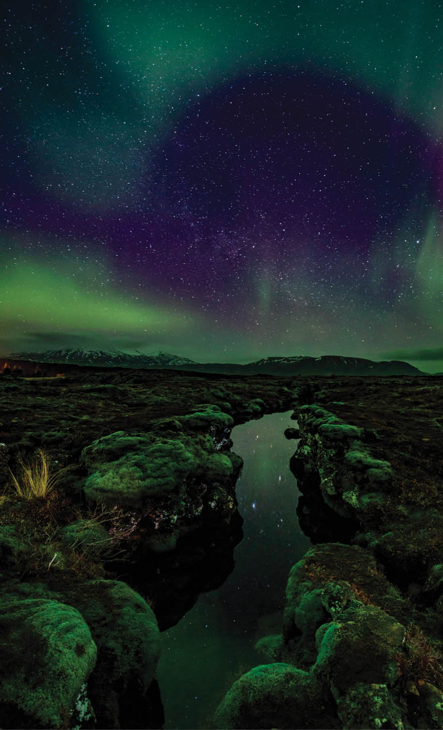 Aurora over the Silfra rift on the tectonic plates which straddle Iceland. The rift is full of gin clear water which is reflecting the aurora.