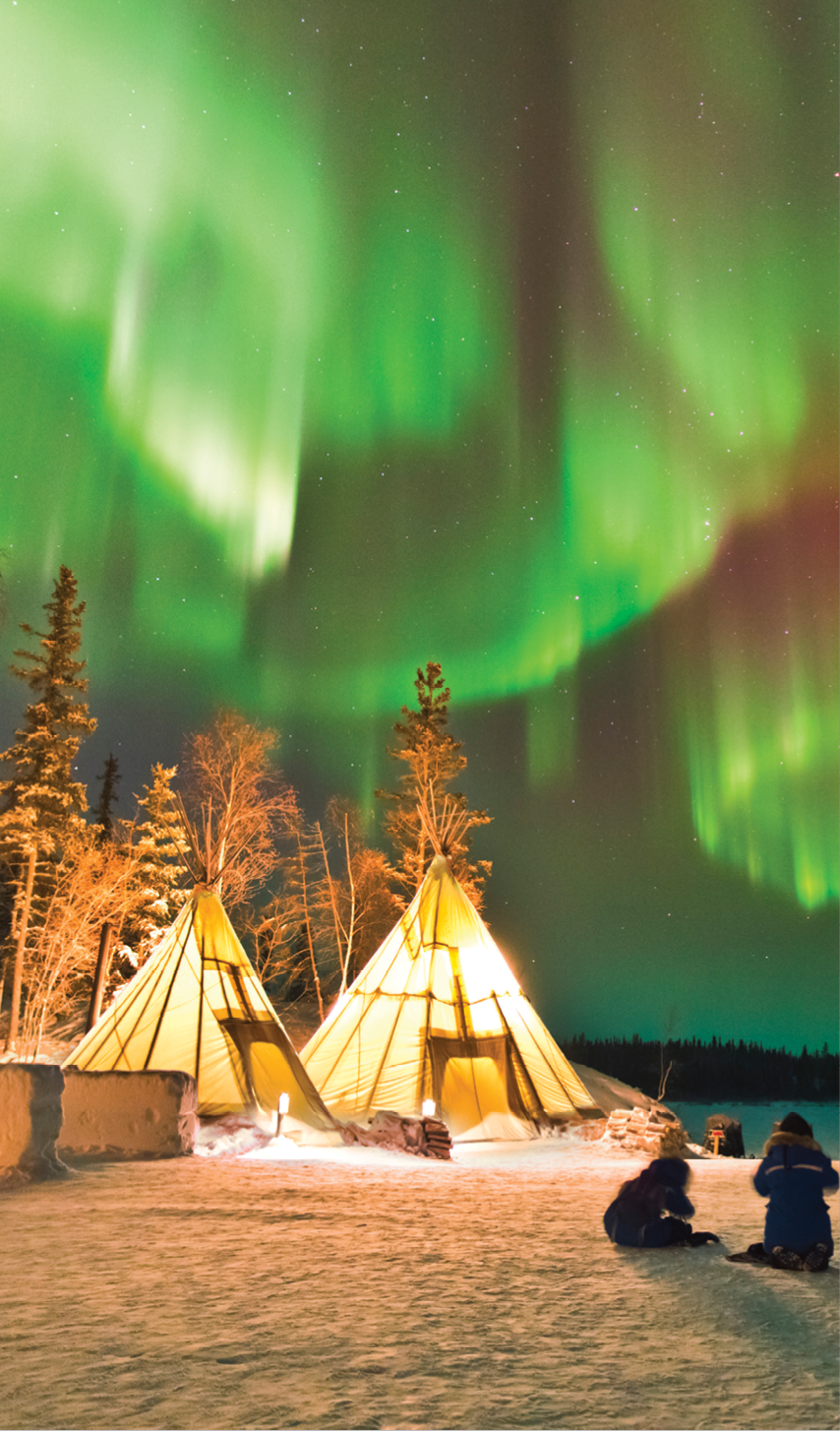 Aurora Village in Yellowknife, Canada is a popular destination to see the Northern Lights up close. The camp’s glowing teepees complement the colorful ribbon of lights above.