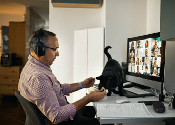 Businessman working with colleague through video conferencing from his home during coranavirus lockdown 