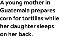 A young mother in Guatemala prepares corn for tortillas while her daughter sleeps on her back.