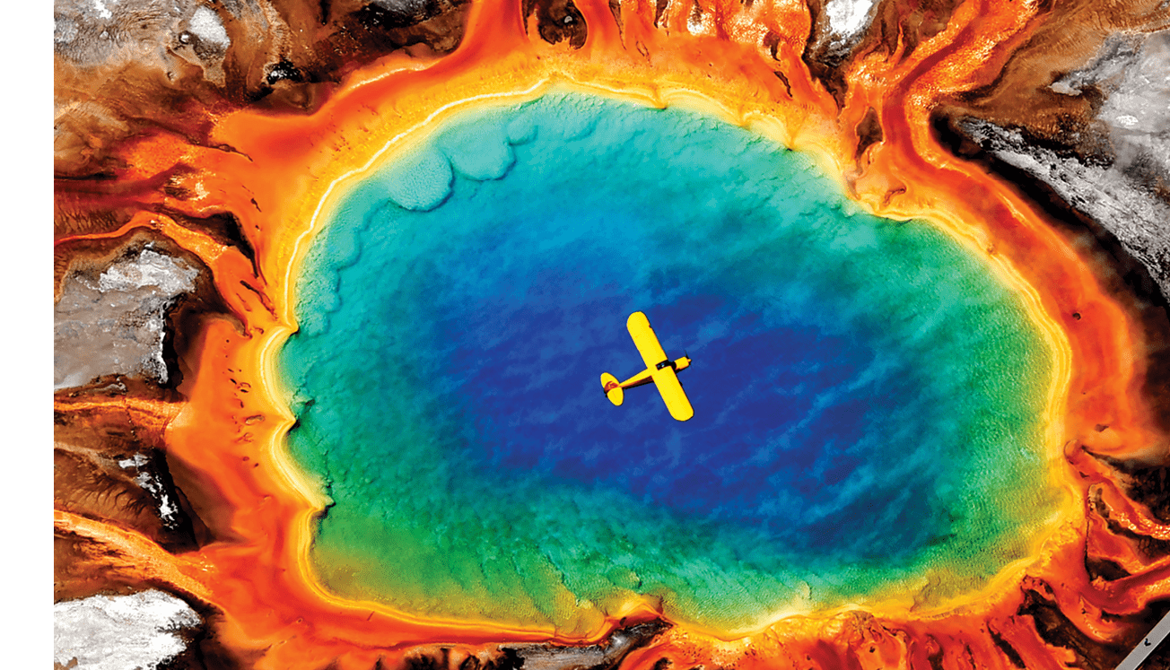Brian Kjensmo flies his Piper Super Cub over Grand Prismatic Spring in Yellowstone National Park in July, 2010. The picture was used on the cover of the SuperCubs.org calendar.