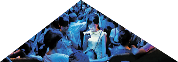 On a hot day in Hong Kong, people crowded into an air-conditioned train. When the lights dimmed, one young woman stood out, lost in the glow of her own digital world.