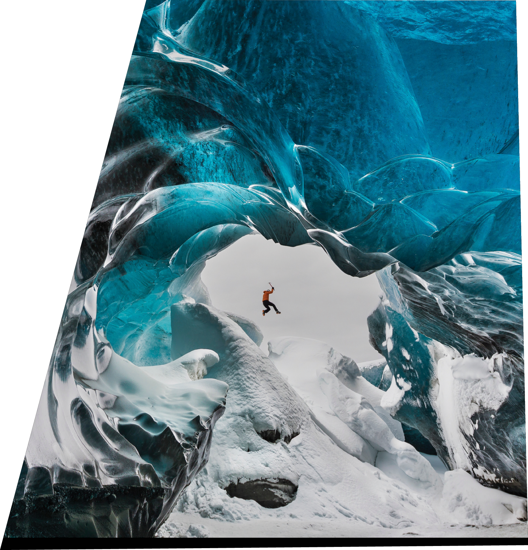 Man jumping across piles of snow in Crystal Cave of Vatnajokull ice cap, Iceland