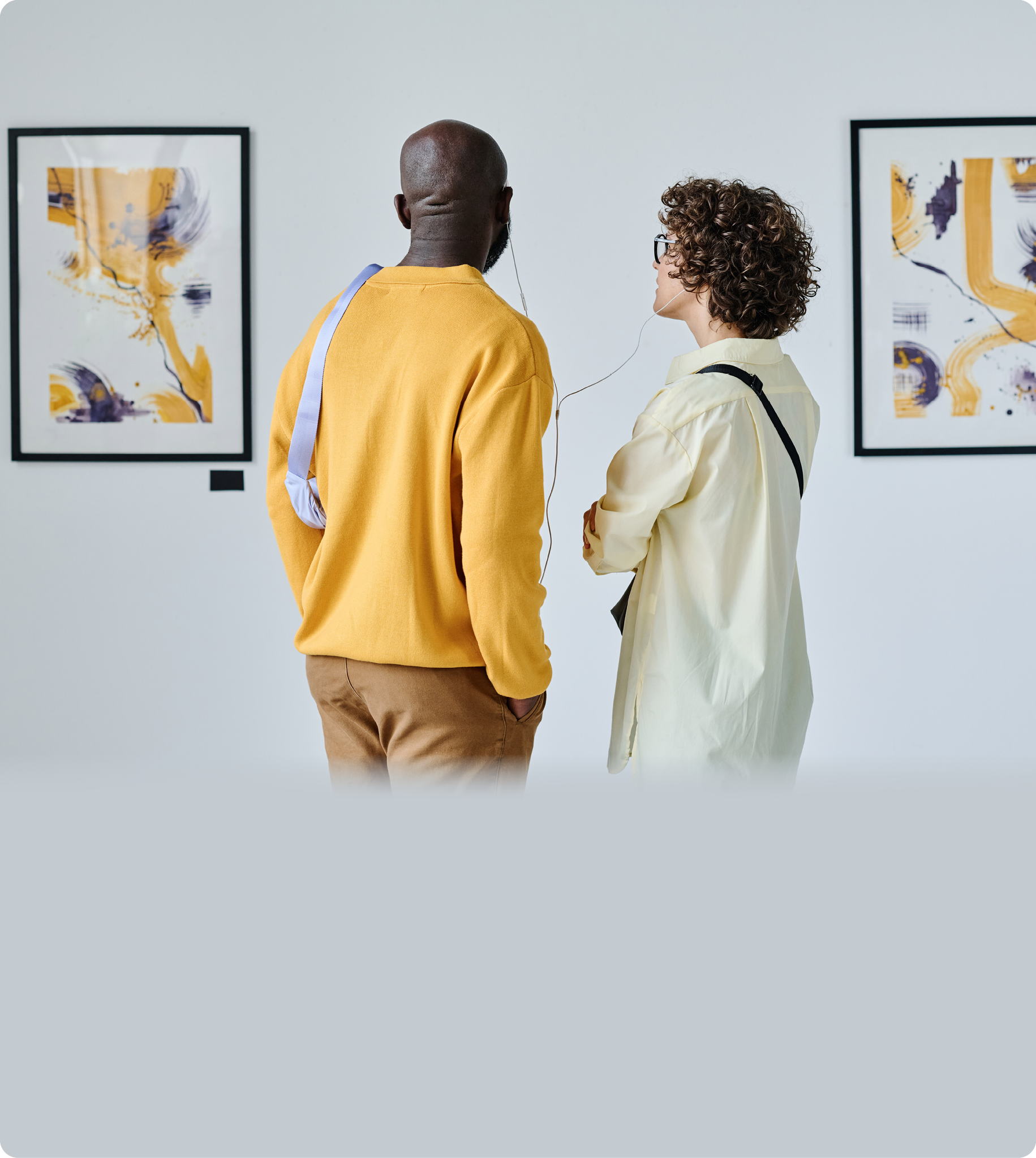 Rear view of young multiethnic couple enjoying the beautiful modern art at art gallery