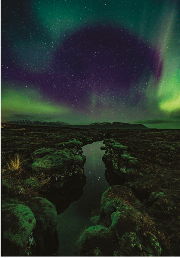 Aurora over the Silfra rift on the tectonic plates which straddle Iceland. The rift is full of gin clear water which is reflecting the aurora.
