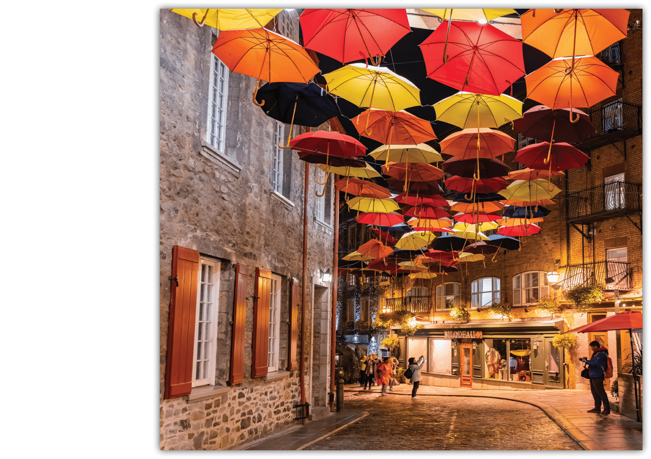 Quebec, OCT 3: Night view of the Breakneck Steps area with colorful umbrella hanging on OCT 3, 2018 at Quebec, Canada; Shutterstock ID 1311496772; NGL Division: ELT; Program Title: World Link; Client/Licensee: National Geographic Learning/Cengage Learning; ISBN: 9780357502136