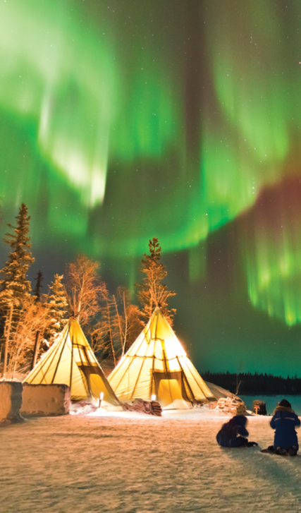 Aurora Village in Yellowknife, Canada is a popular destination to see the Northern Lights up close. The camp’s glowing teepees complement the colorful ribbon of lights above.