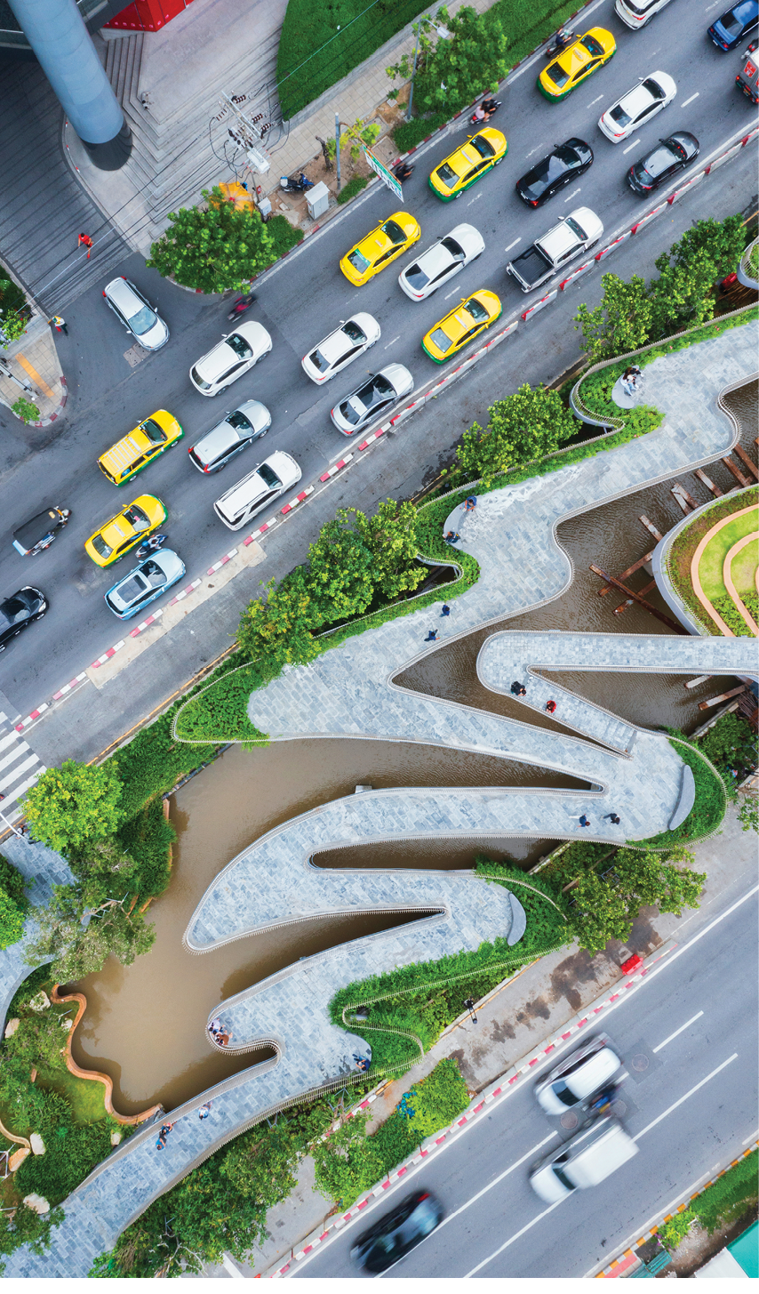 Aerial view of curve road by trees in city.
