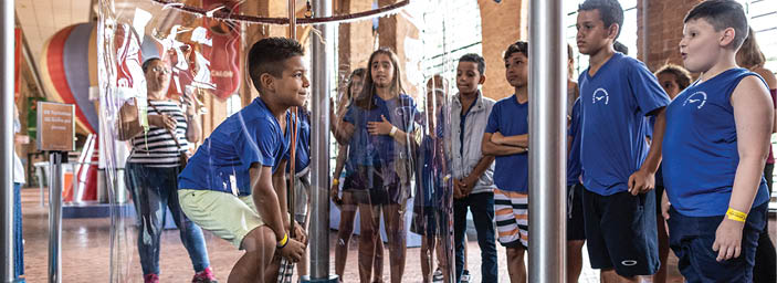 Children exploring and learning science, through large bubble makers, electrostatic and motion, all at the Catavento Museum, offering a fascinating spectrum of science and technology exhibits supporting the pillars of universe, life, ingenuity, and society. Catavento houses many interactive exhibits, 3D tours, virtual reality experiences, educational game shows, a robotics display, an aquarium, and a butterfly garden, among many other intriguing offerings. (Releases in SP Museu Catavento, SP Folder 6)