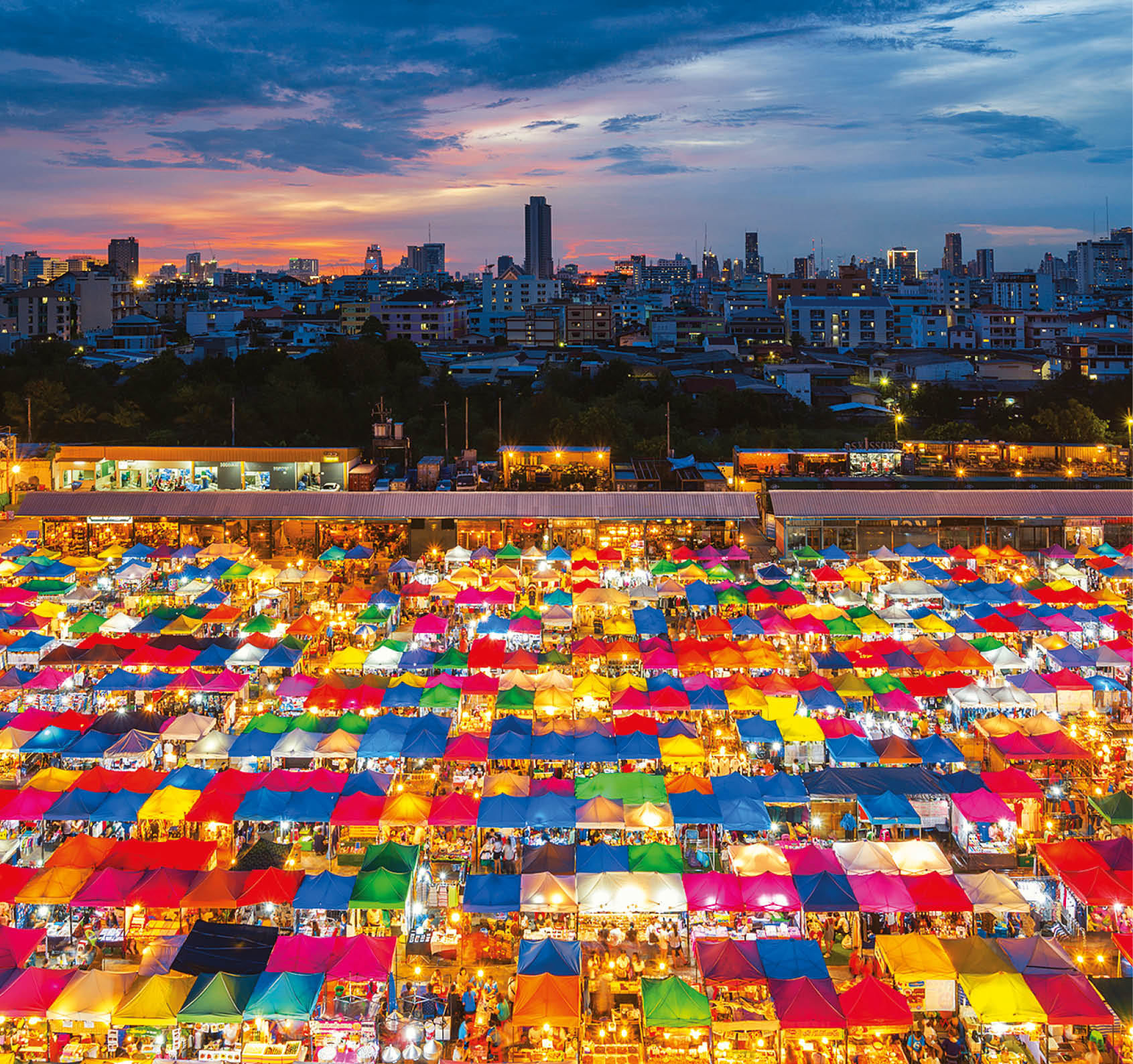 Night scene of colorful tent and cityscape at Chatujak market secondhand market in Bangkok , Thailand