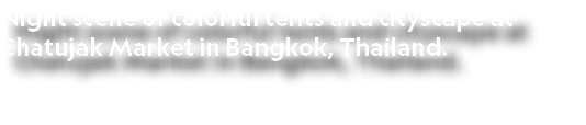 Night scene of colorful tents and cityscape at Chatujak Market in Bangkok, Thailand. 