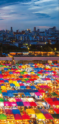 Night scene of colorful tent and cityscape at Chatujak market secondhand market in Bangkok , Thailand