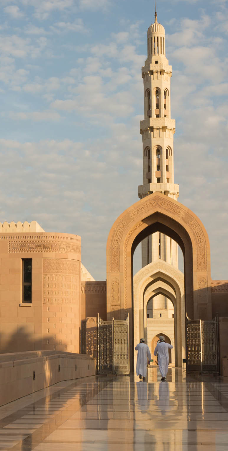Oman, Sunrise at the Sultan Qaboos Grand Mosque is one of the most famous mosques in the world. Sultan Qaboos was involved in planning every detail of the mosque, which claims to have the largest handmade Persian rug and Swaravski Crystal Chandelier.  The mosque grounds are surrounded by flowers.