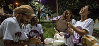 A group of musicians perform and sign traditional Coco music at a parl in Olinda, Brazil. The name “Coco" (Portuguese for "coconut") is a common Northeastern Brazilian slang for head, referring to the fact that song lyrics are often improvised. Coco is often performed with a repetitive musical beat and call and response singing reminiscent of Capoeira music. The music is commonly performed at traditional parties in the Northeast, such as weekend street parties and Carnival. Coco is also alternatively known as "embolada" (another slang word, meaning "entangling", referring to the fast, slurred, machine-gun style of singing). (Releases in R Capoeira , R Folder 2)