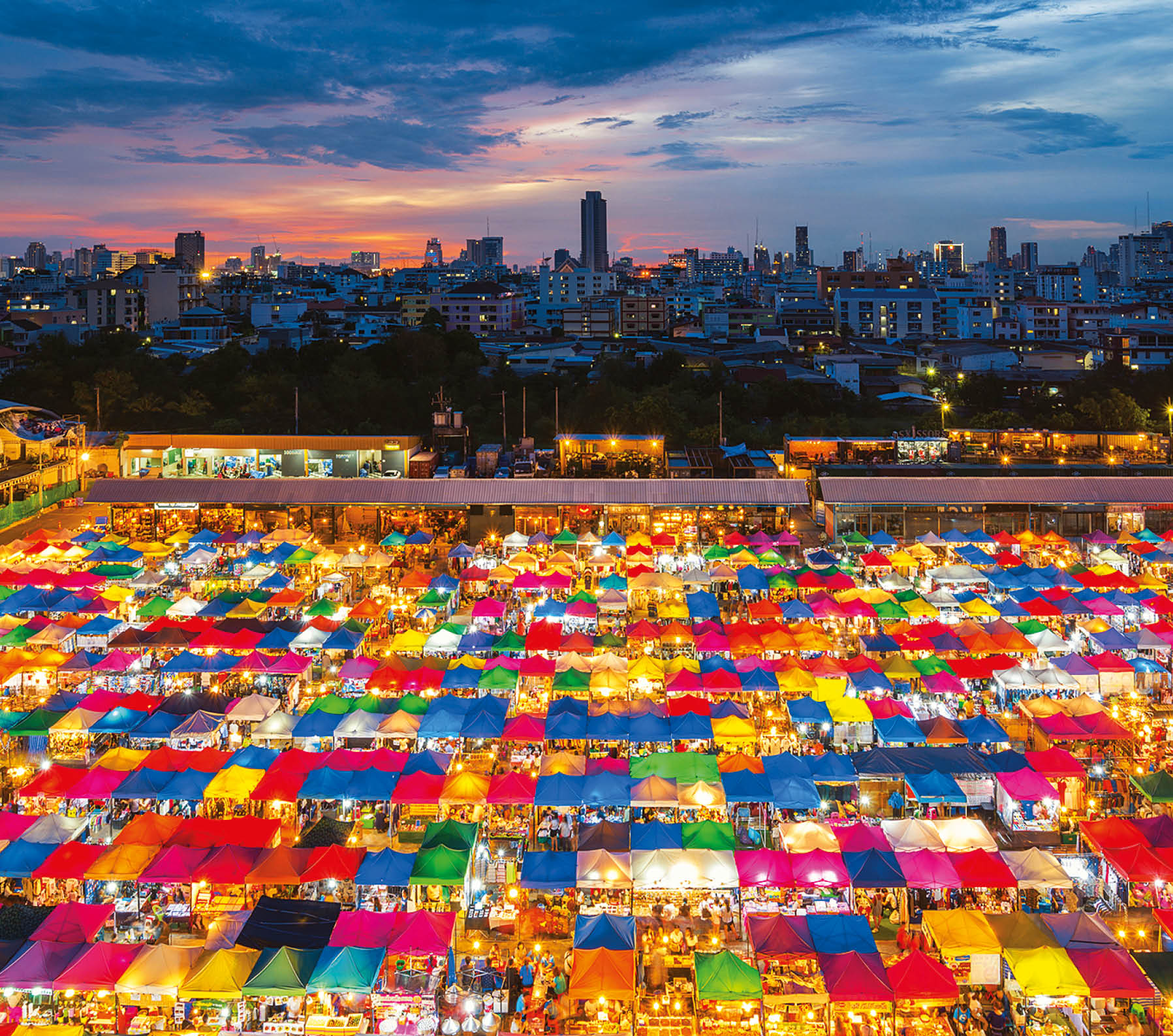 Night scene of colorful tent and cityscape at Chatujak market secondhand market in Bangkok , Thailand