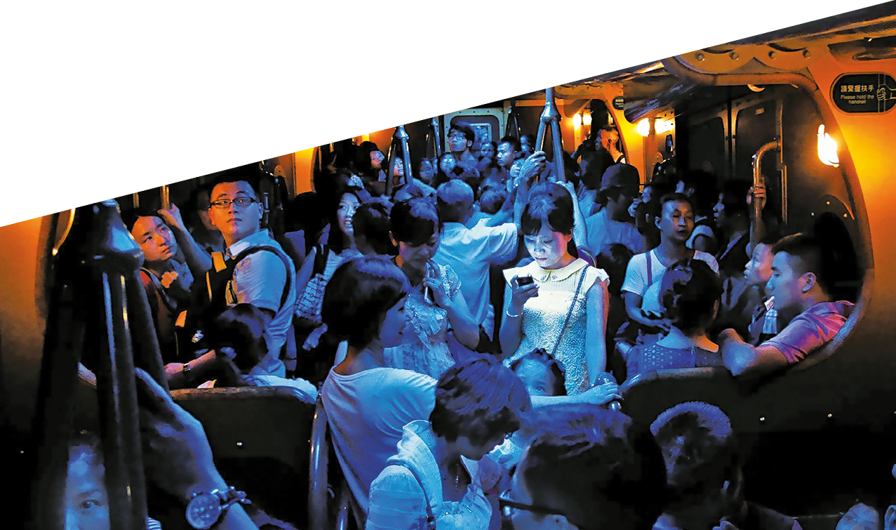 On a hot day in Hong Kong, people crowded into an air-conditioned train. When the lights dimmed, one young woman stood out, lost in the glow of her own digital world.