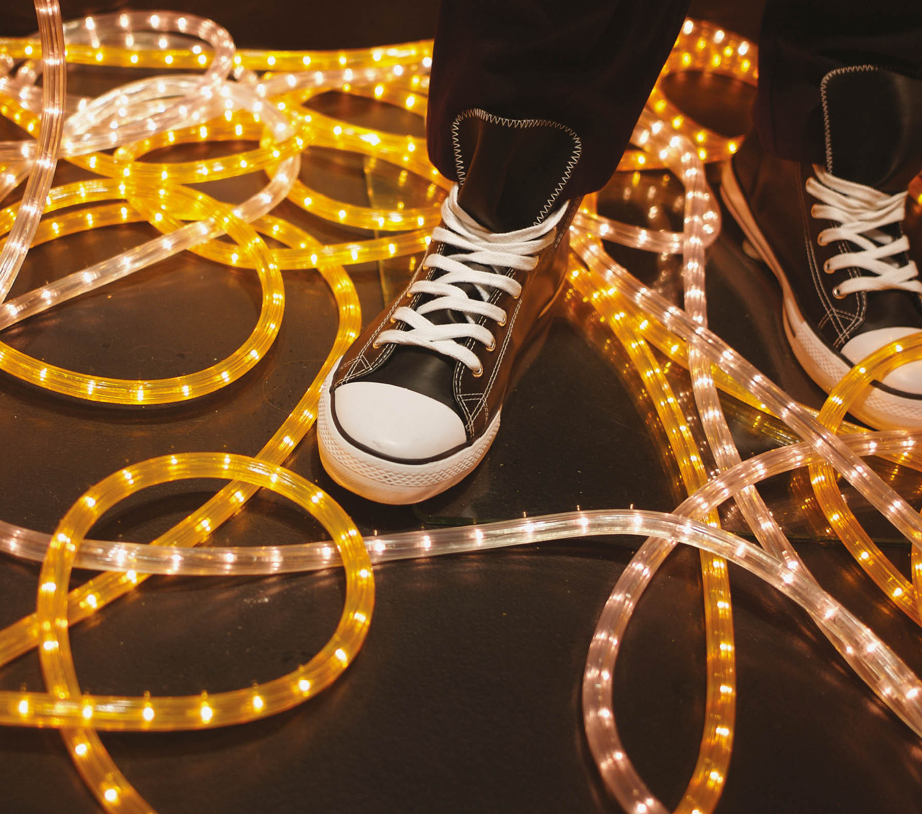 Sneaker displayed in window, yellow neon light