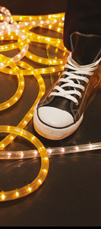 Sneaker displayed in window, yellow neon light