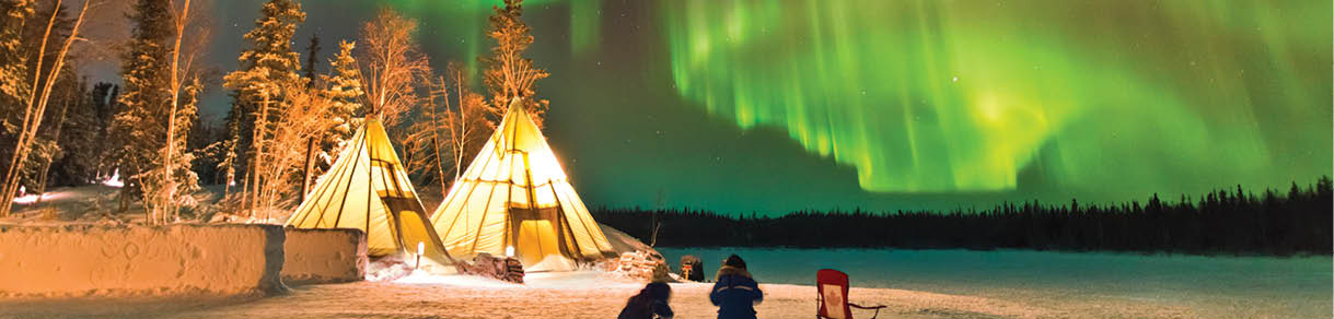 Aurora Village in Yellowknife, Canada is a popular destination to see the Northern Lights up close. The camp’s glowing teepees complement the colorful ribbon of lights above.