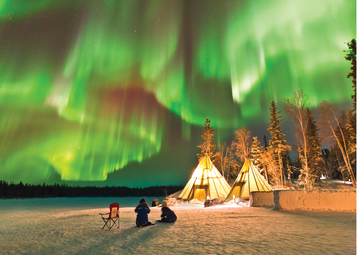 Aurora Village in Yellowknife, Canada is a popular destination to see the Northern Lights up close. The camp’s glowing teepees complement the colorful ribbon of lights above.
