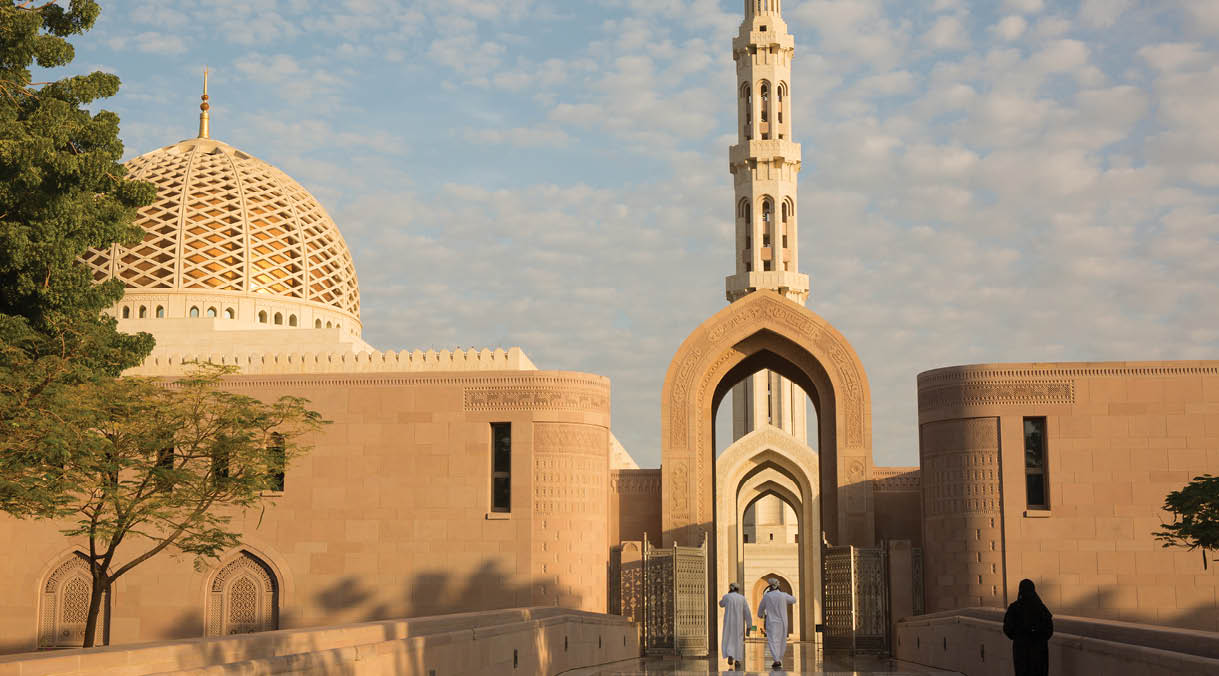 Oman, Sunrise at the Sultan Qaboos Grand Mosque is one of the most famous mosques in the world. Sultan Qaboos was involved in planning every detail of the mosque, which claims to have the largest handmade Persian rug and Swaravski Crystal Chandelier.  The mosque grounds are surrounded by flowers.